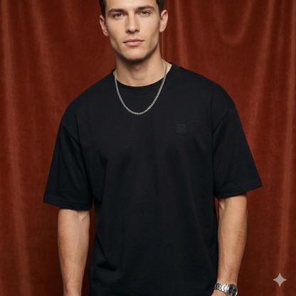Close-up of WEARON Logo Patch Tee in Black on model, rust velvet backdrop.