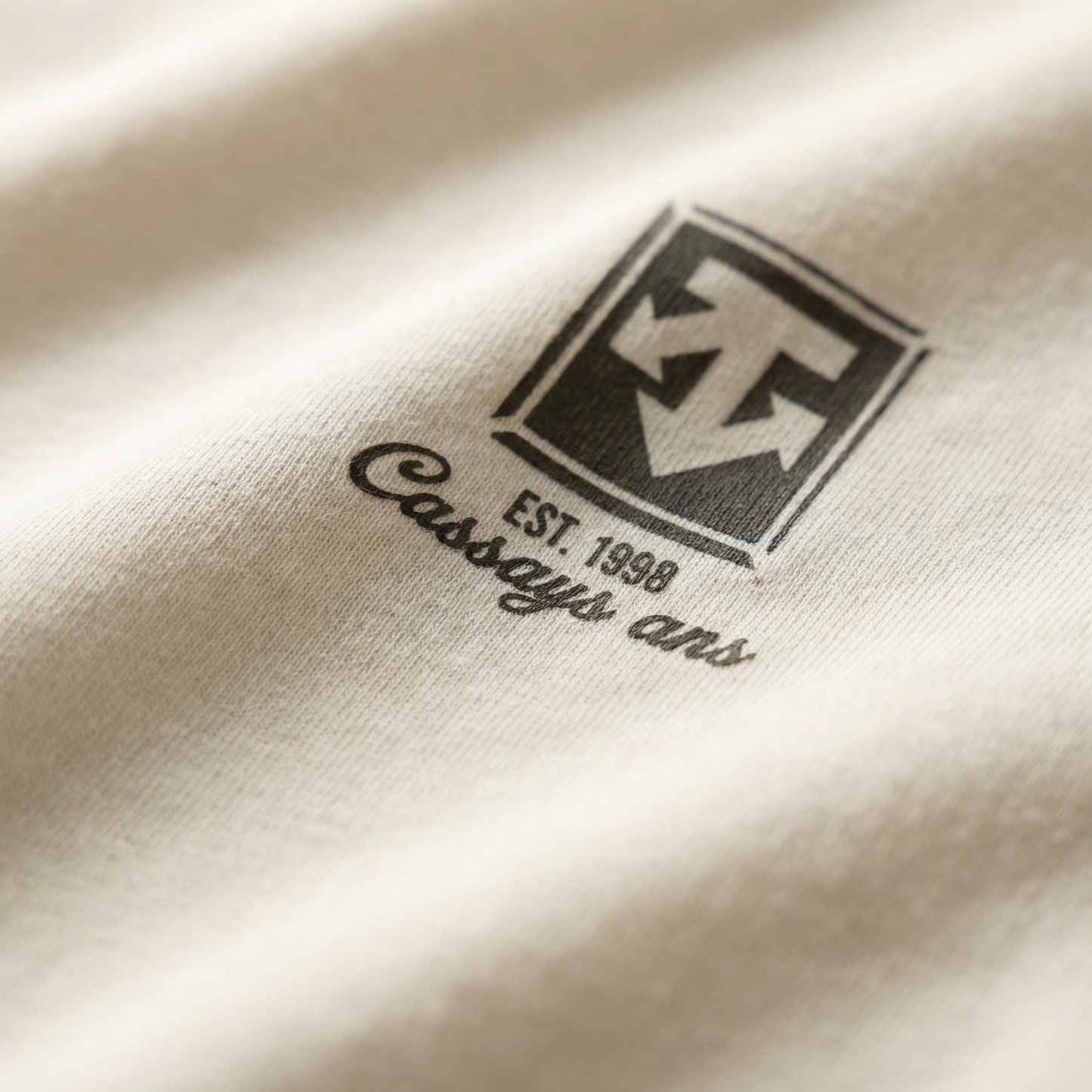 Macro detail of crest print on Ivory cotton tee.