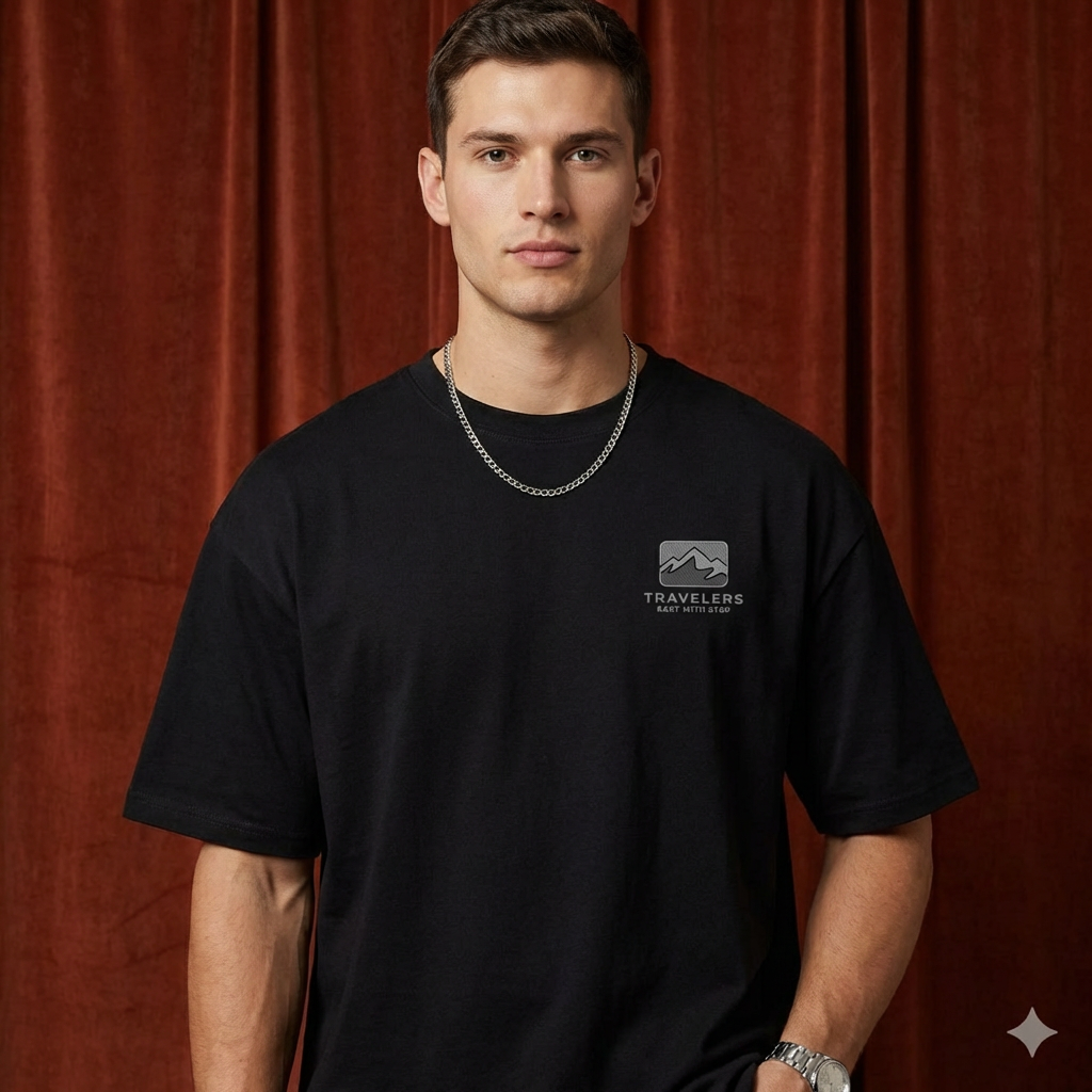 Close-up of WEARON Travelers Mountain Tee in Black with chest mountain logo print, rust velvet backdrop.