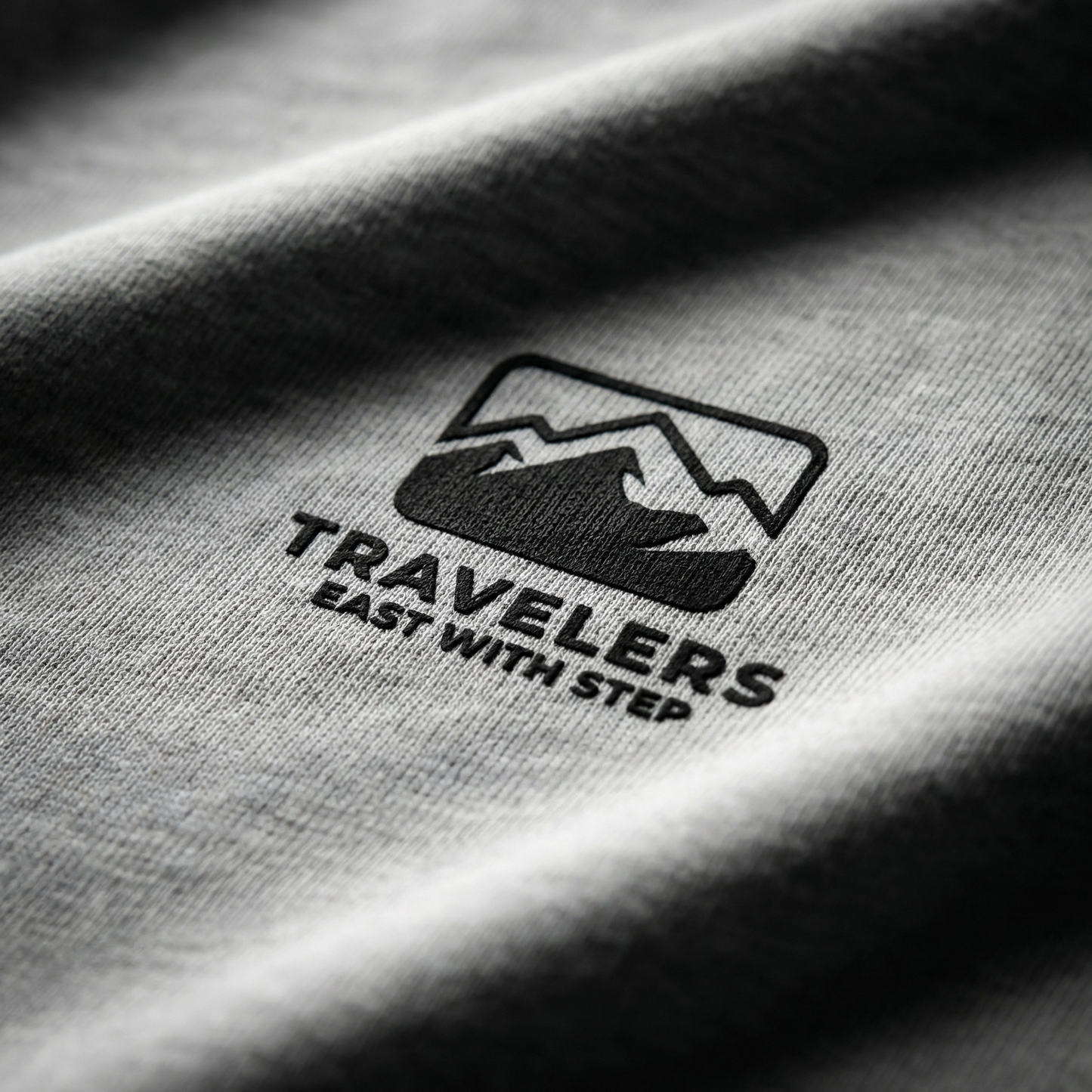 Macro detail of mountain logo print on Heather Gray cotton tee.