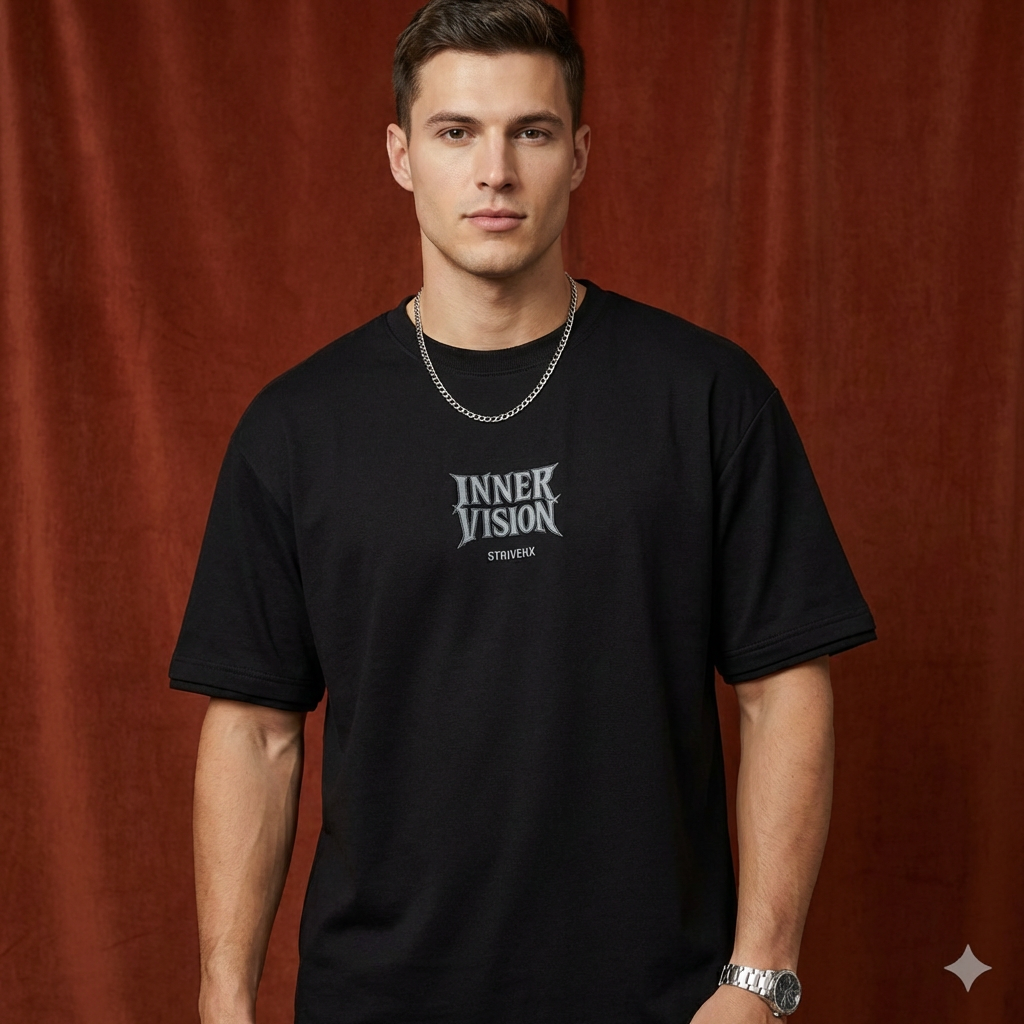 Close-up of WEARON Inner Vision Tee in Black with chest typographic print, rust velvet backdrop.
