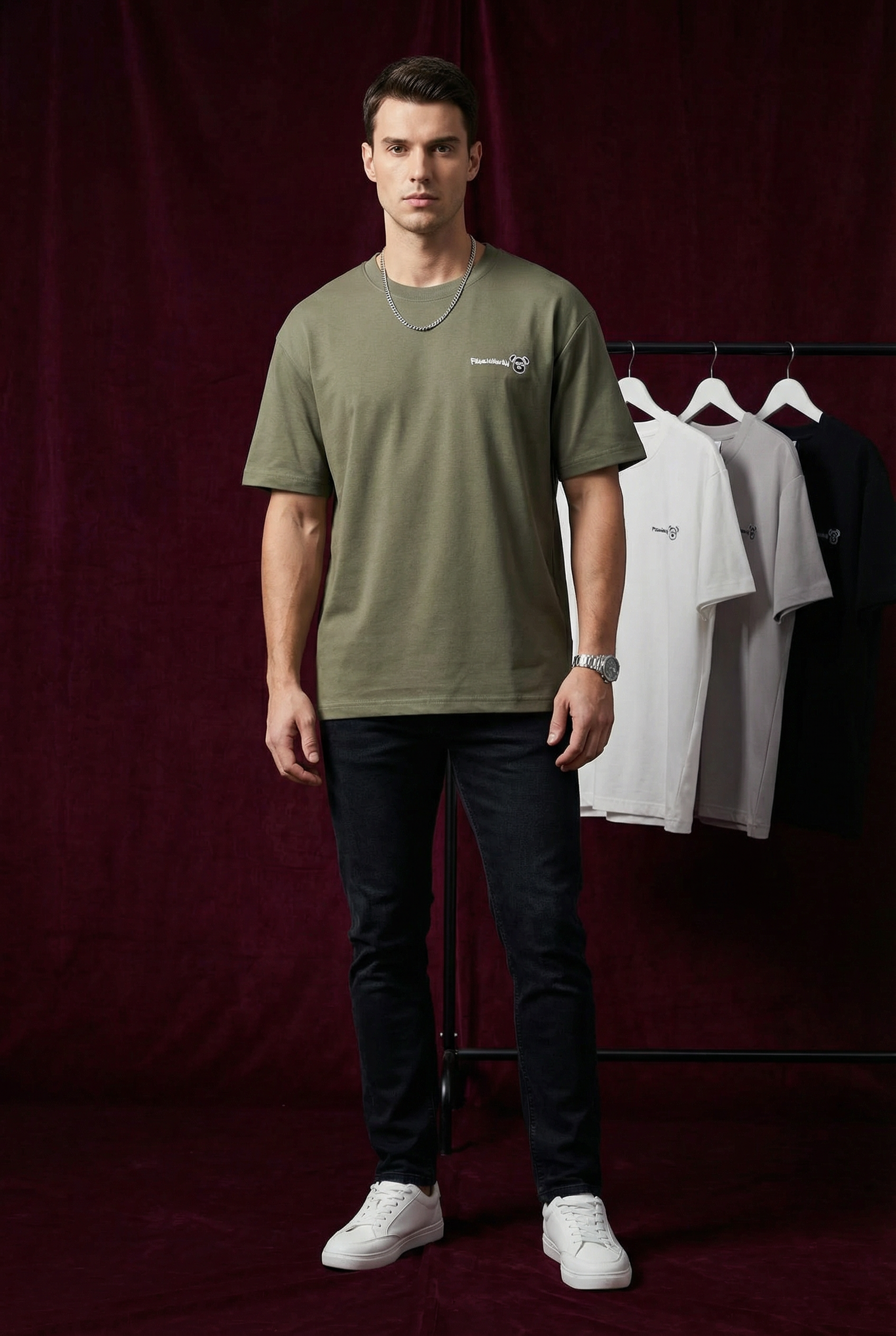 Close-up of WEARON Bear Patch Tee in White showing small embroidered bear-face motif, dark backdrop.