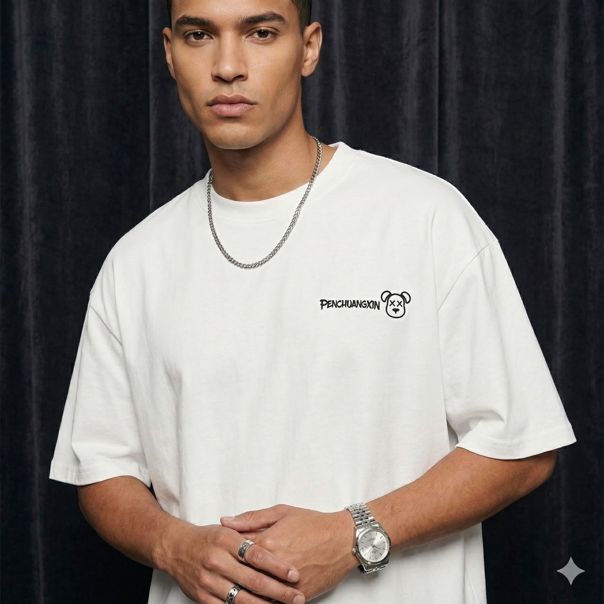 Alternate close-up of WEARON Bear Patch Tee in White with embroidered bear motif, deep teal velvet backdrop.