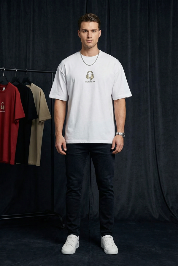 Man wearing WEARON Headphones Tee in White, full body with rolling rack of colourways, dark studio backdrop.