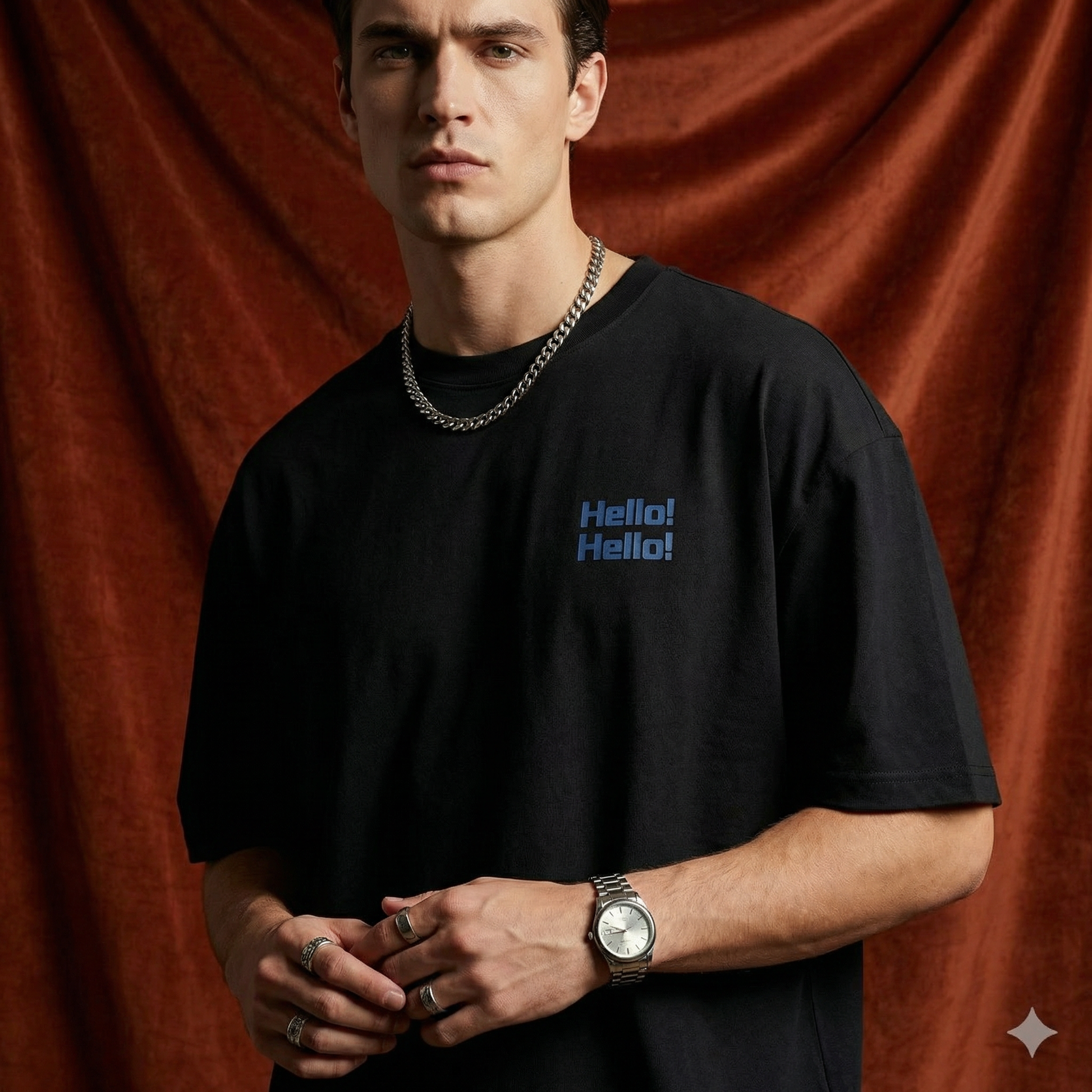 Close-up of WEARON Hello Tee in Black with chest 'Hello! Hello!' print, rust velvet backdrop.