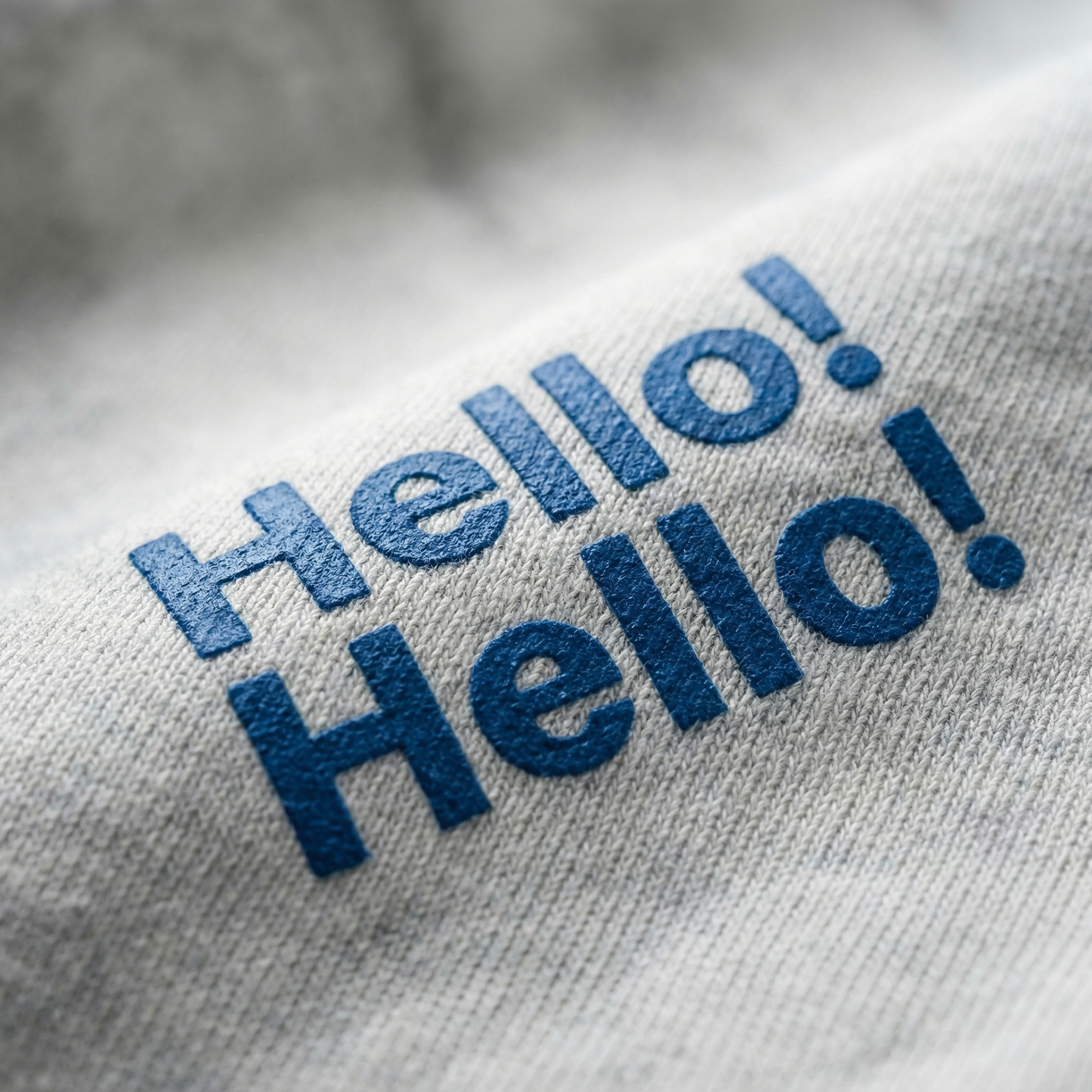 Macro detail of 'Hello! Hello!' chest print on Light Gray cotton tee.