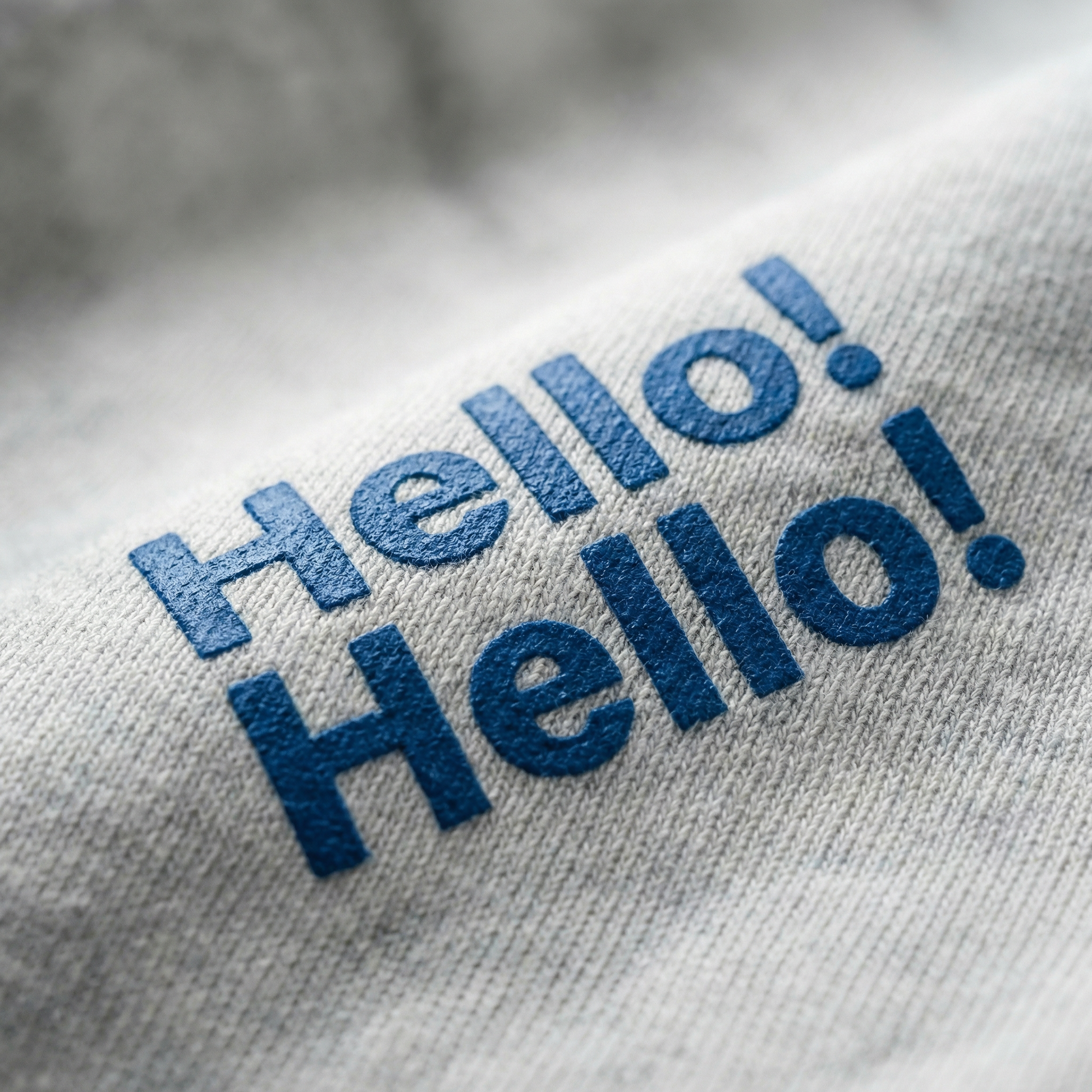 Macro detail of 'Hello! Hello!' chest print on Light Gray cotton tee.