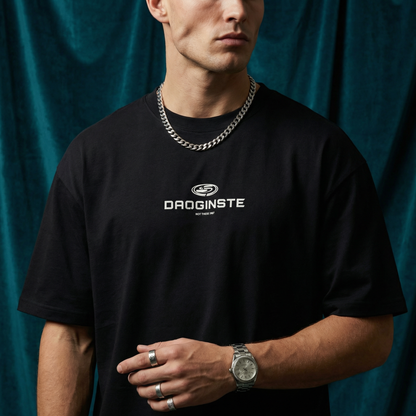 Close-up of WEARON Sport Logo Tee in Black with chest sport emblem print, deep teal velvet backdrop.
