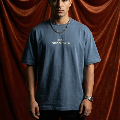 Man wearing WEARON Sport Logo Tee in Slate Blue, full body, rust velvet backdrop.