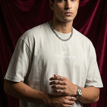 Close-up of WEARON Sport Logo Tee in Stone with chest sport emblem print, burgundy velvet backdrop.