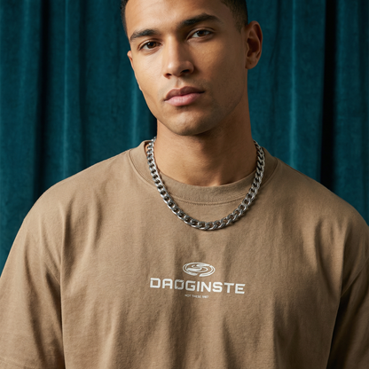 Close-up of WEARON Sport Logo Tee in Tan with chest sport emblem print, deep teal velvet backdrop.