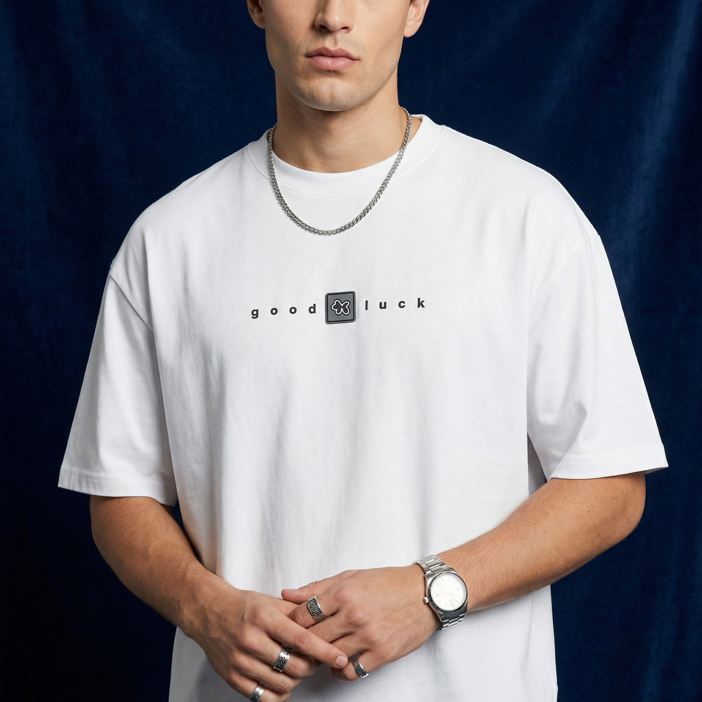 Man wearing WEARON Good Luck Tee in White, close-up showing chest typography, navy backdrop.