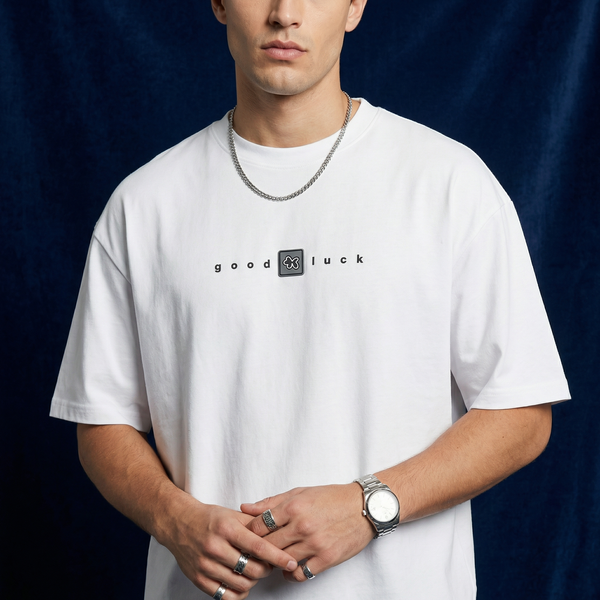 Man wearing WEARON Good Luck Tee in White, close-up showing chest typography, navy backdrop.