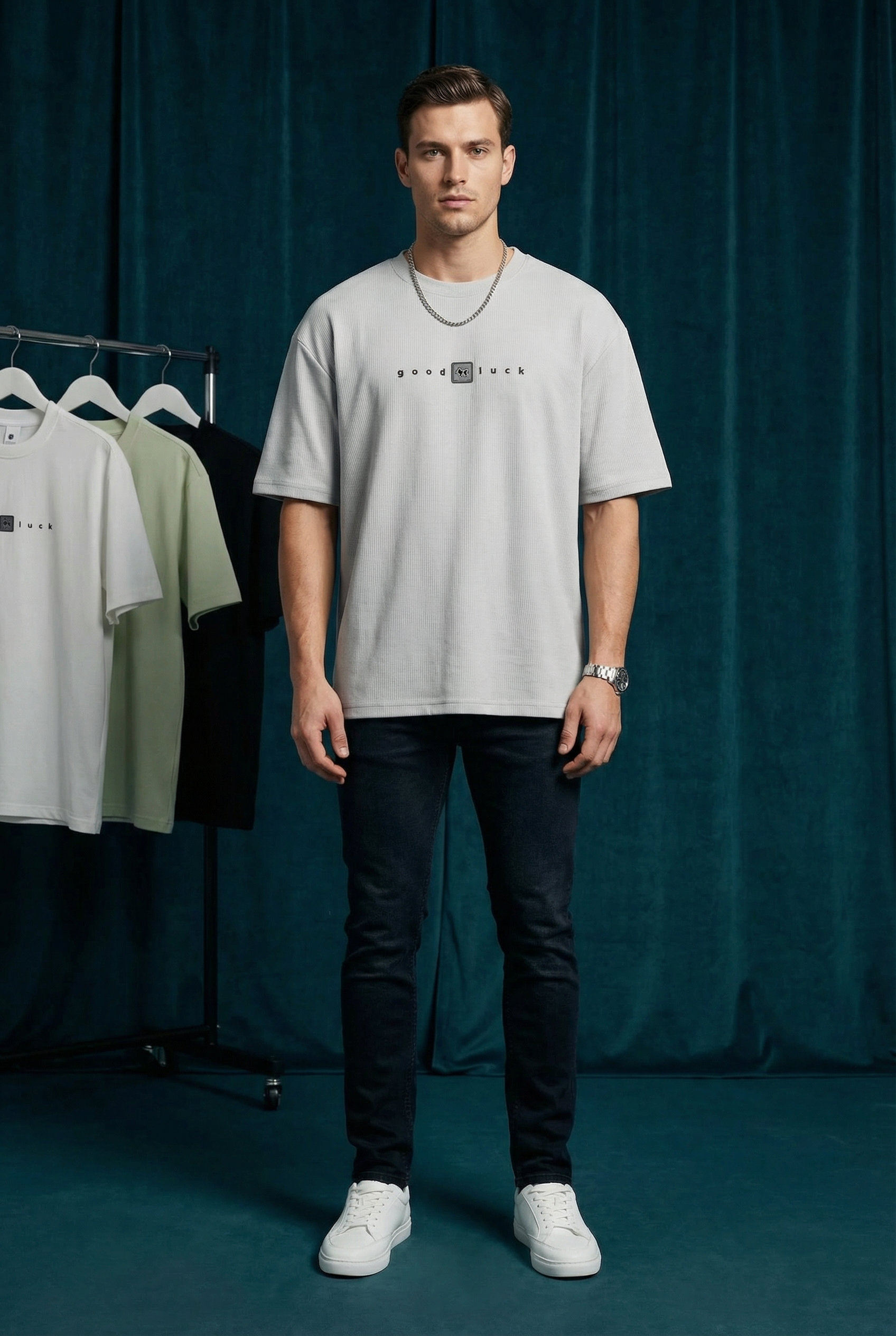 Full body view of WEARON Good Luck Tee in White, dark studio backdrop with rolling rack.