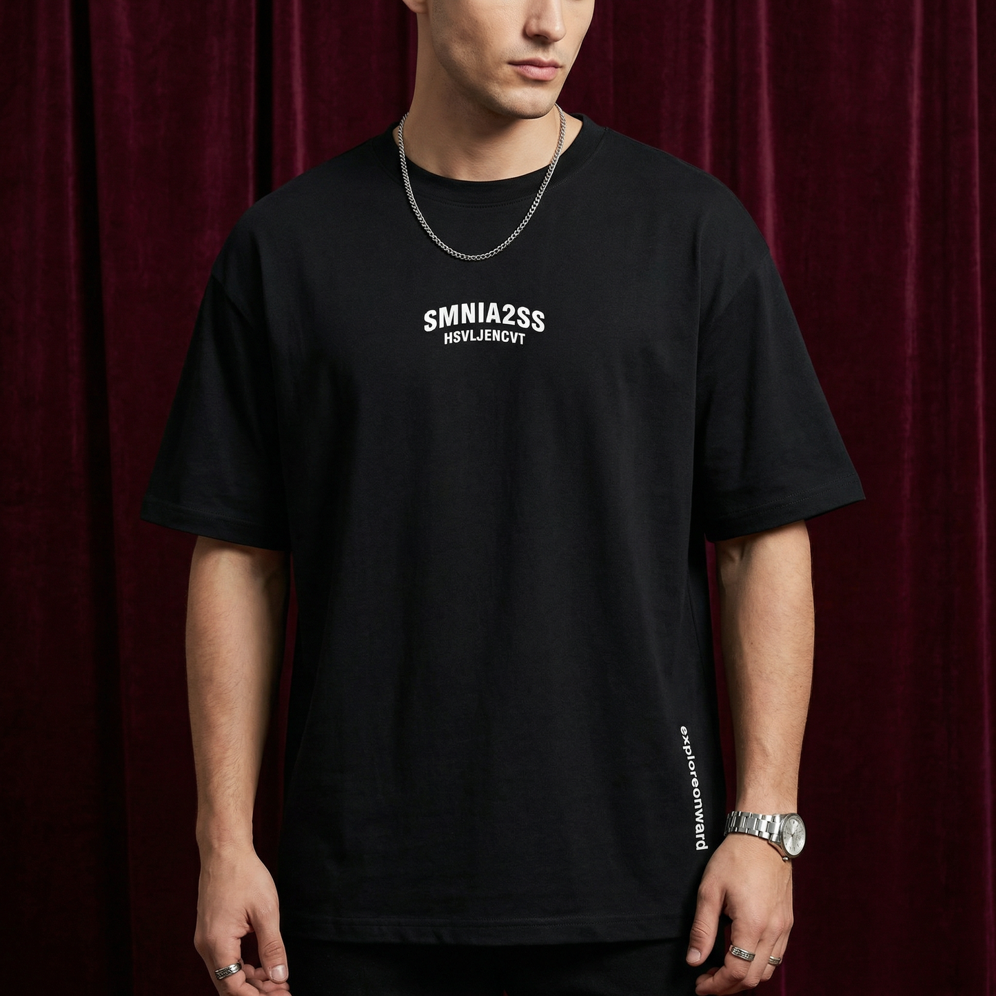 Close-up of WEARON Explore Onward Tee in Charcoal with side 'explore onward' typography, burgundy backdrop.