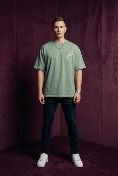 Man wearing WEARON Patch Detail Tee in Sage, full body, deep purple velvet backdrop.