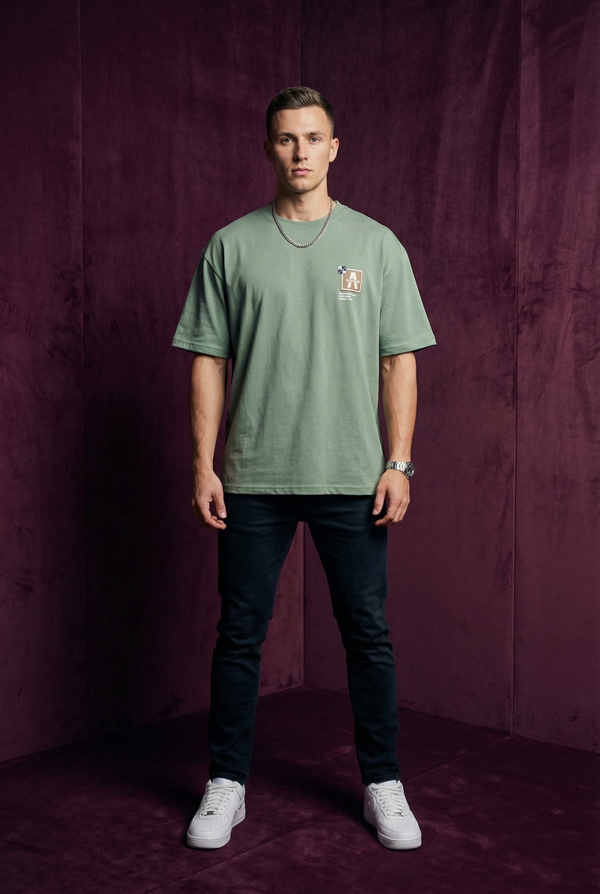 Man wearing WEARON Patch Detail Tee in Sage, full body, deep purple velvet backdrop.