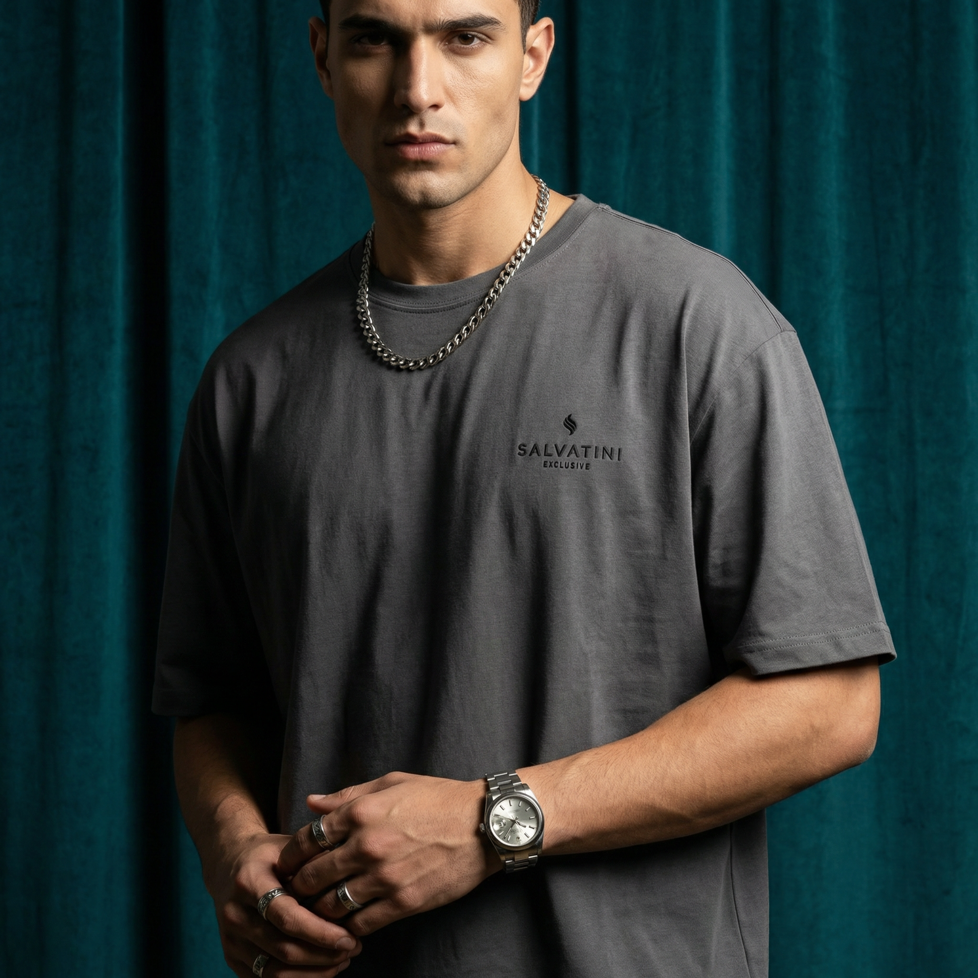 Close-up of WEARON Premium Logo Tee in Charcoal with chest logo print, deep teal velvet backdrop.