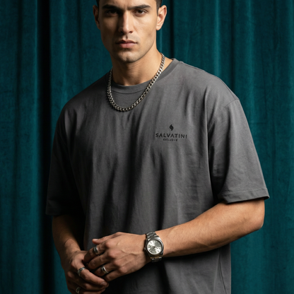 Close-up of WEARON Premium Logo Tee in Charcoal with chest logo print, deep teal velvet backdrop.