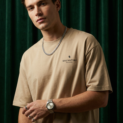 Close-up of WEARON Premium Logo Tee in Tan with chest logo print, deep green velvet backdrop.