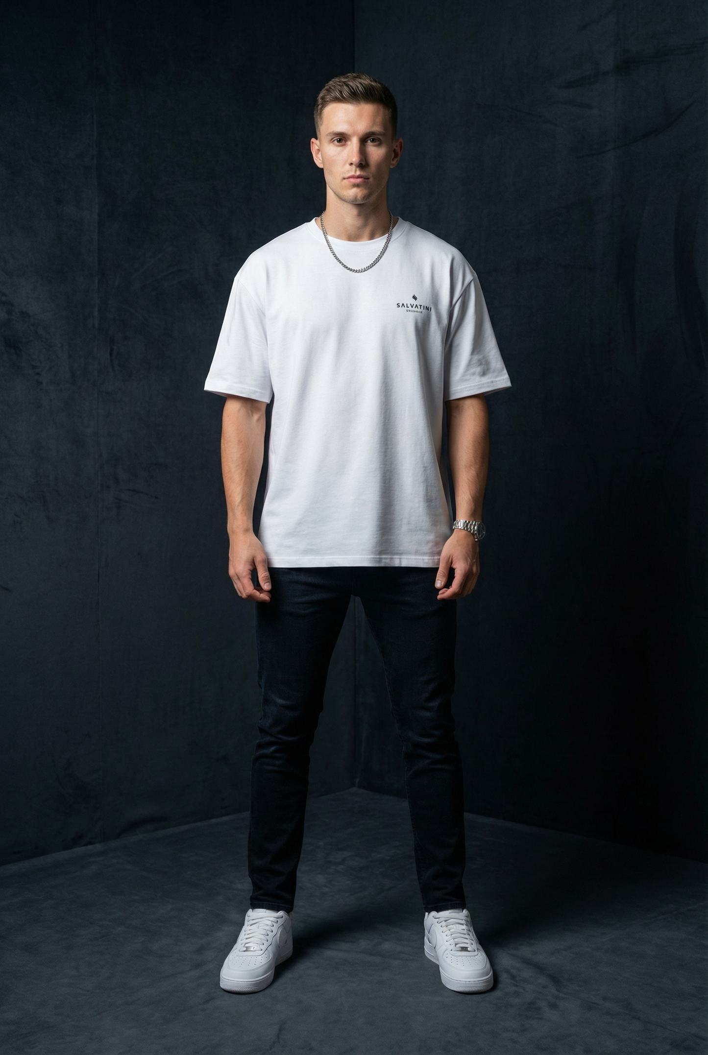 Man wearing WEARON Premium Logo Tee in White, full body, dark studio backdrop.