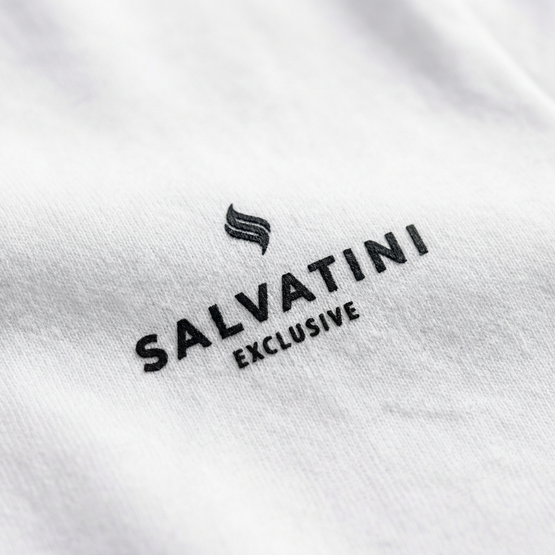 Macro detail of chest logo print on White cotton tee.