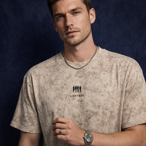 Man wearing WEARON Mineral-Wash Tee in Beige with mineral-wash effect, deep blue velvet backdrop.