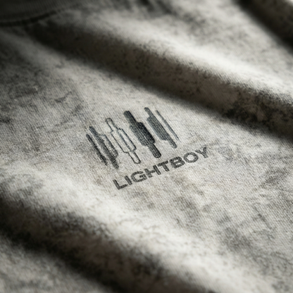 Macro detail of chest emblem and mineral-wash texture on Gray cotton tee.