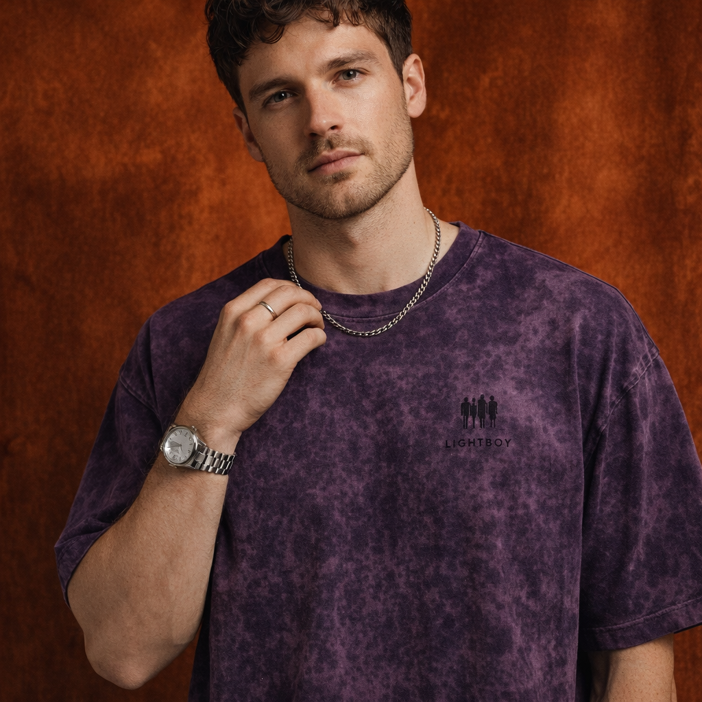 Close-up of WEARON Mineral-Wash Tee in Purple, rust curtain backdrop.