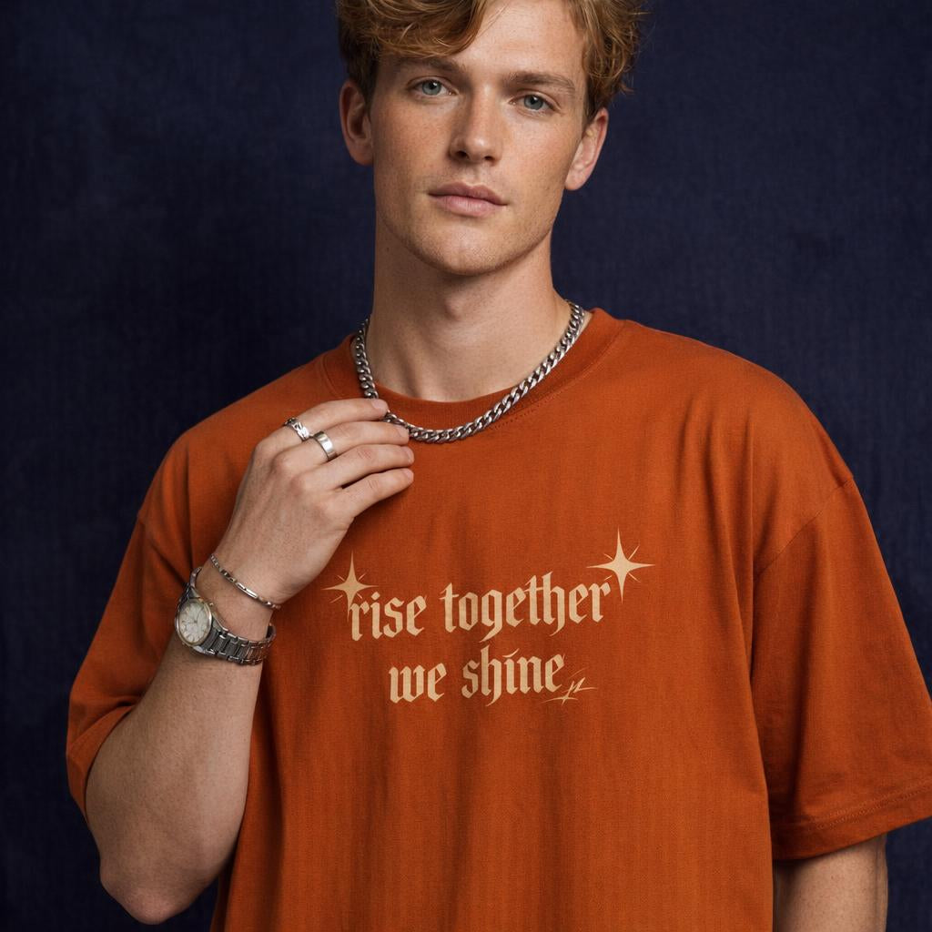 Close-up of WEARON Rise Together Tee in Forest Green with metallic foil 'rise together we shine' print, burgundy velvet backdrop.