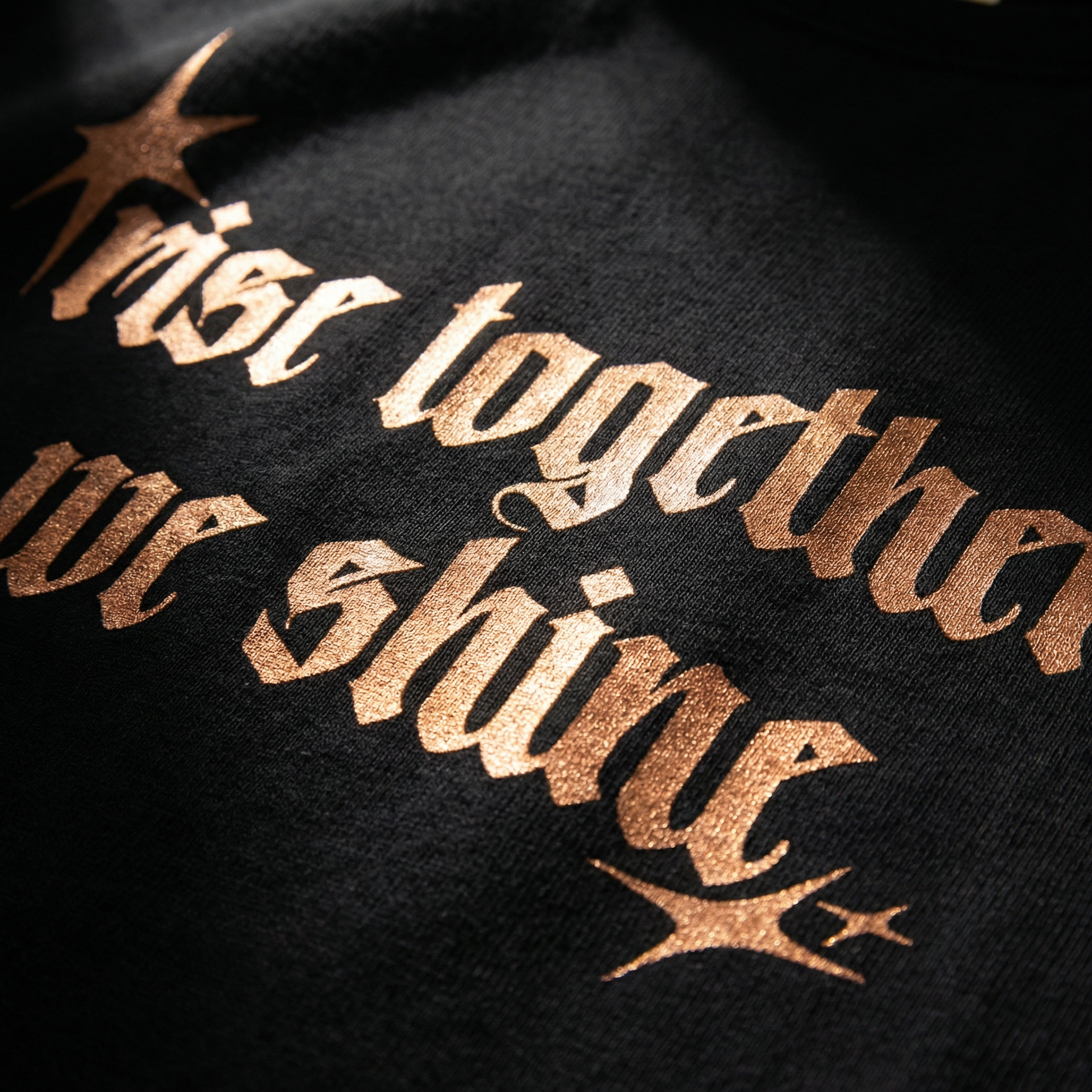Close-up of WEARON Rise Together Tee in Burnt Orange showing metallic foil chest typography.