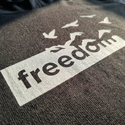 Macro detail of Freedom birds graphic on Charcoal cotton hoodie tee.