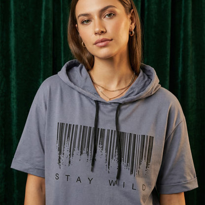 Close-up of WEARON Short-Sleeve Hoodie Tee in Gray with Stay Wild barcode graphic, deep green velvet backdrop.