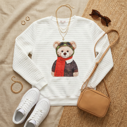 Flat lay of WEARON Teddy Bear Quilted Sweatshirt in Aviator graphic styled with white sneakers, tan crossbody bag, gold jewellery.