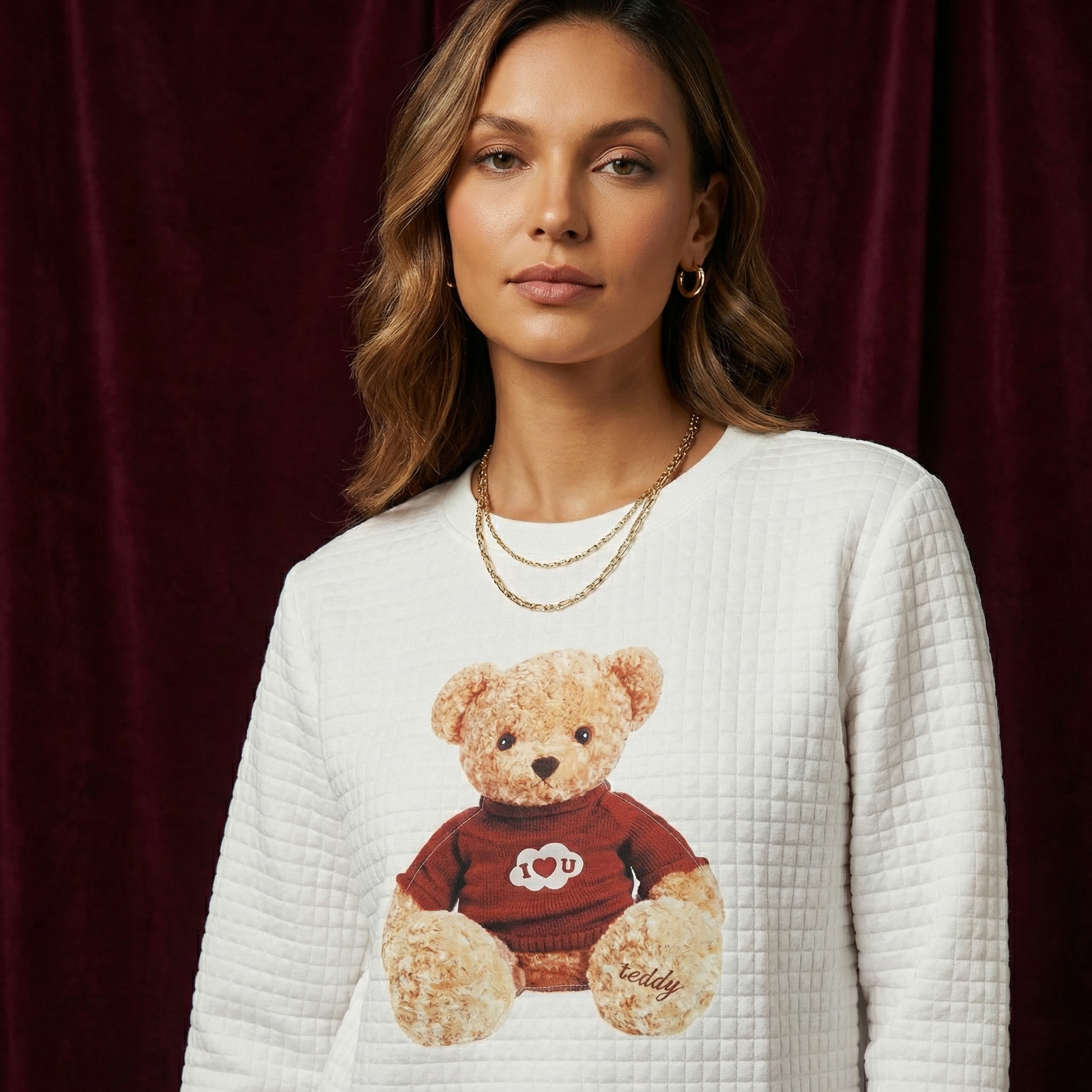 Close-up of WEARON Teddy Bear Quilted Sweatshirt with I Heart U teddy graphic, burgundy velvet backdrop.