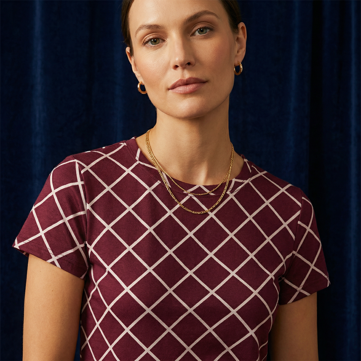 Close-up of WEARON Diamond Lattice Tee in Burgundy with cream bias-set windowpane lattice print, navy velvet backdrop.